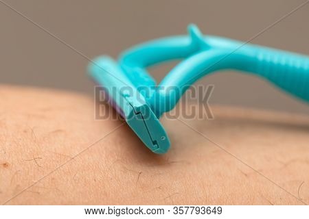 Close Up Picture Of Woman Holding Razor, Shaving Her Hairy Leg With Folliculitis