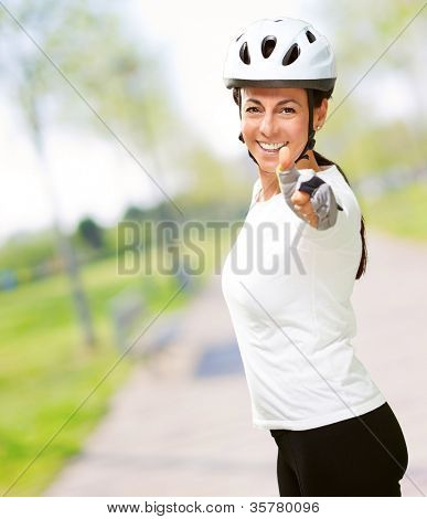 Femme portant casque montrant le pouce vers le haut, en plein air