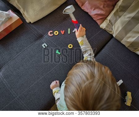 Covid-19, Corona Virus. A Little Boy Hammers The Covid Typography With A Hammer Away, A Symbol For F