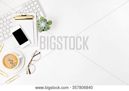 Top View Of Office Desk. Table With Keyboard, Smartphone, Clipboard And Office Supplies. Flat Lay Ho
