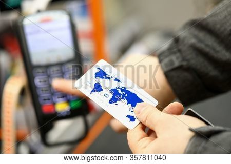Male Hand Holding Banking Card While Paying With It At Cash Desk Of Supermarket Close-up