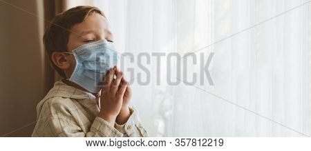 Coronavirus Covid-19. Child Praying To God Requesting That The Coronavirus Covid 19 Not Spread Beyon