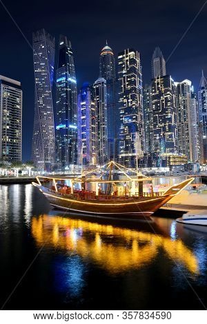Dubai, Uae - November 15: The Night Illumination Of Dubai Marina And Traditional Dhow Boat,  On Nove