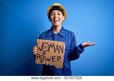 Young blonde worker woman asking for women rights holding banner with power message very happy and excited, winner expression celebrating victory screaming with big smile and raised hands