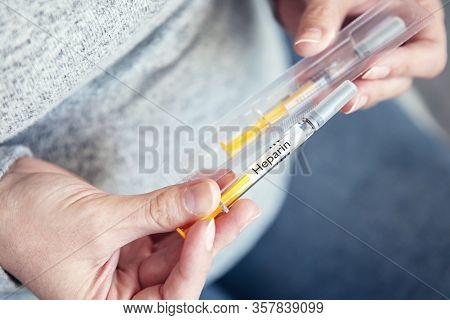 Woman's Hands Hold Disposable Syringe With Heparin