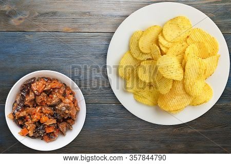 Potato Chips On A White Plate With Vegetarion Salad. Chips On A Blue Wooden Background Top View.