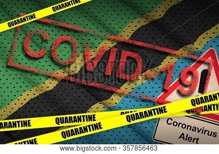 Tanzania Flag And Covid-19 Quarantine Yellow Tape With Red Stamp. Coronavirus Or 2019-ncov Virus