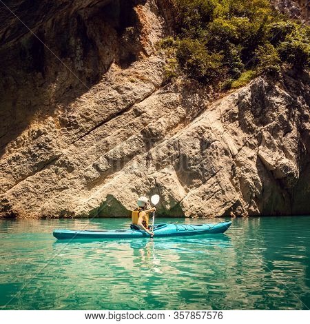 Woman on a kayak in the Pyrenees mountains in Catalonia on the waters of the Mont Rebei Gorge