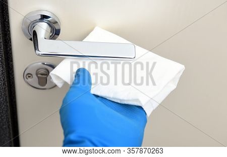 Disinfection In Public Places, The Fight Against The Virus, Coronavirus.worker's Hand Wipes The Door