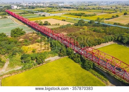 red famous Xilou Bridge over the river and farm in Yunlin county, Taiwan