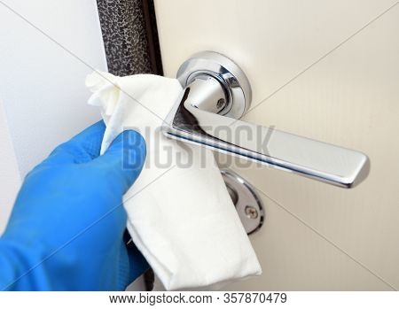 Disinfection In Public Places, The Fight Against The Virus, Coronavirus.worker's Hand Wipes The Door