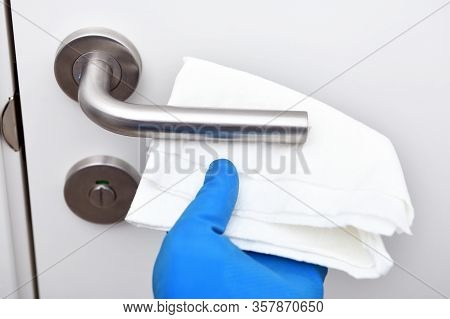 Disinfection In Public Places, The Fight Against The Virus, Coronavirus.worker's Hand Wipes The Door