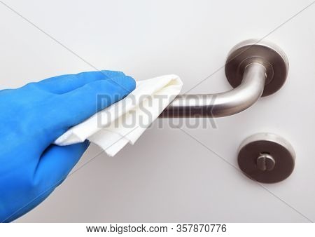 Disinfection In Public Places, The Fight Against The Virus, Coronavirus.worker's Hand Wipes The Door