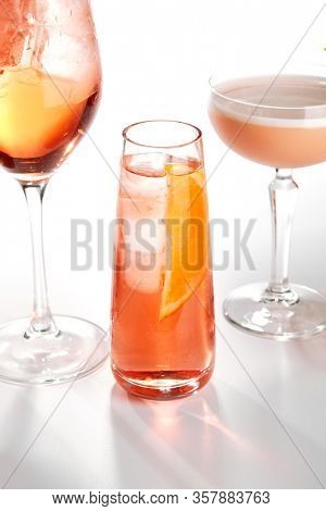 Negroni tonic cocktail close up. Alcohol strong aperitif drink in glasses side view. Beverage with vermouth, liqueur, gin and orange slice in drinkware. Cocktail portion in glassware