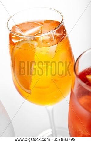 Orange Spritz cocktail. Alcohol soft drink in glass side view. Refreshment beverage with fruit puree in drinkware. Exotic summer beach cocktail portions with crushed ice in glassware