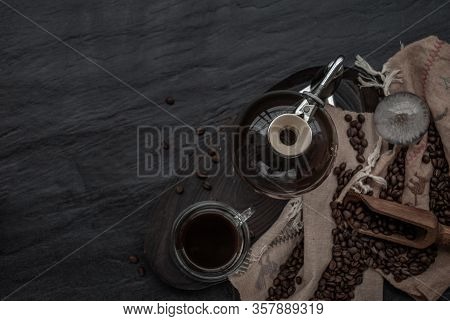 Coffee Style, Cup Of Coffee And Coffee Beans Roating With Old Wooden Scoop And Coffee Beans Around O
