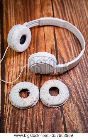 Need A Replacement Embouchures On Old White Earbud. Repair Accessories.wooden Background
