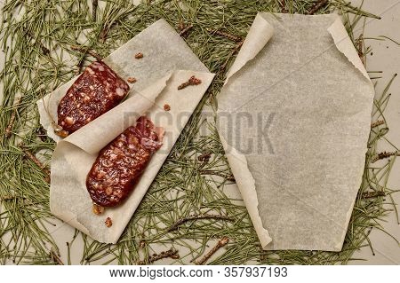Dried Sausage Made Of Beaver Meat On Parchment Left And Right With A Rolled-up Empty Paper Scroll On
