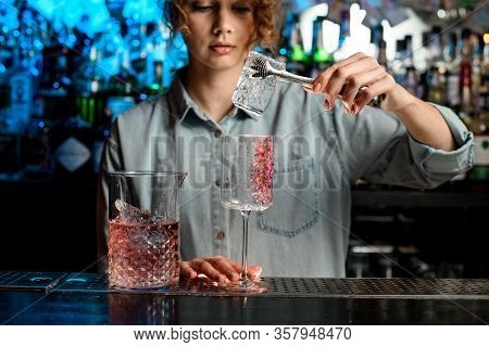 Young Woman Bartender Puts Large Piece Of Ice Into Wineglass
