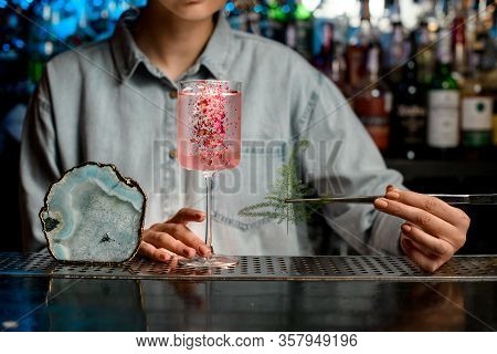 Lady Barman Begin To Decorate Glass With Rose Cocktail By Piece Of Green Plant.