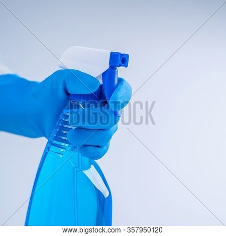 Young Woman Housekeeper In Apron Is Doing Cleaning With Blue Gloves, Wet Yellow Rag, Spraying Bottle