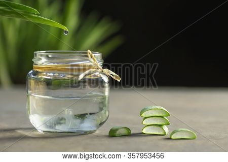 Aloe Vera Gel Close-up. Sliced Aloe Vera Plants Leaf And Gel Pouring Into Jar, Natural Organic Cosme