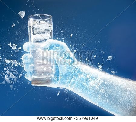 Frozen Hand Holds A Glass Of Cold Water With Ice