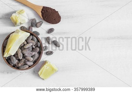 Cocoa Butter Or Cocoa Bean Solid Oil With Cacao Powder In Spoon Or Bowl And Raw Cocoa Beans On Rusti
