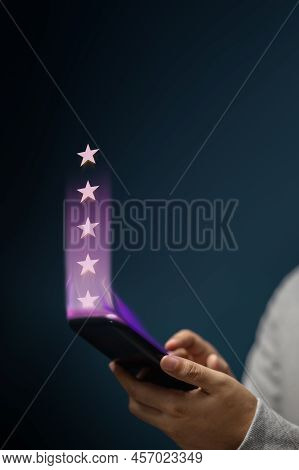 Customer Experiences Concept. Happy Client Using Smartphone To Submit Five Star Review Rating For On