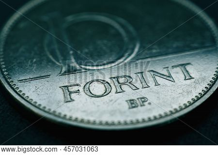 Hungarian Coin Of 10 Forints Lies On A Dark Surface Close-up. Money Of Hungary. News About Economy O