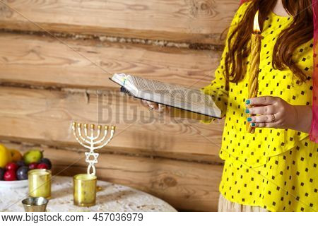 Jewish Religious Woman With An Avdala Candle And A Siddur In Her Hands. Horizontal Photo