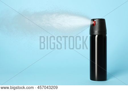 Using Of Pepper Spray On Light Blue Background