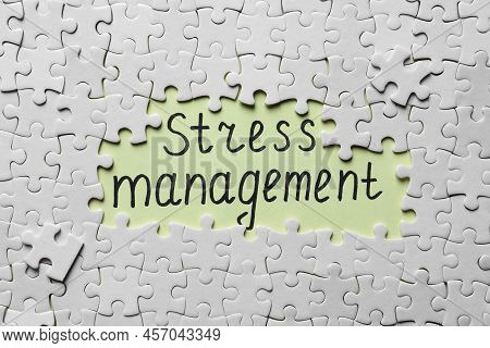 White Puzzle Pieces And Phrase Stress Management Written On Light Green Background, Flat Lay