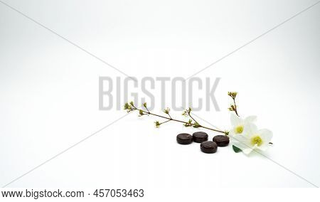 Brown Herbal Lozenges With White Flowers On White Background. Lozenges Tablet For Throat Irritation 