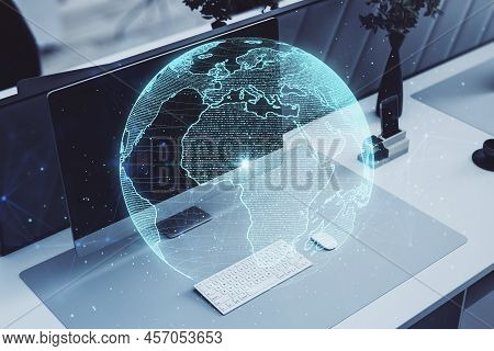 Close Up Of Workplace With Computer Monitor, Keyboard And Creative Glowing Polygonal Grid Planet On 