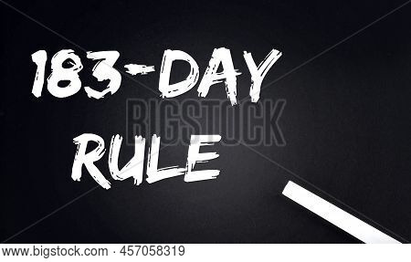 183 Day Rule Text On A Black Chalkboard With A Piece Of Chalk