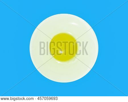 Egg White And Yolk On White Plate (unfried), Isolated Blue Background With Copy Space.