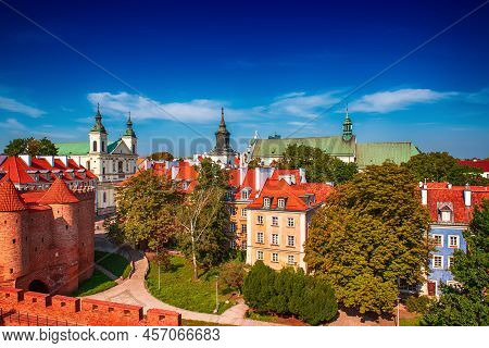 Warsaw, Poland Summer View Of Barbican Or Barbakan Wall And Old Town Houses With Green Trees And Blu