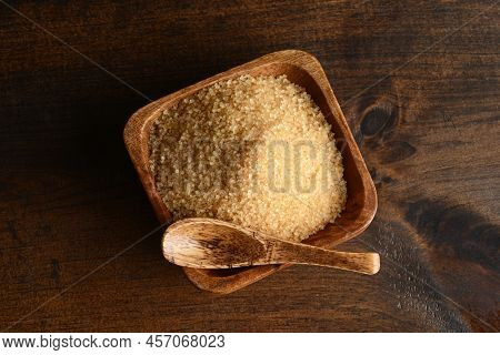 High Angle View Yellow Raw Sugar With Spoon On Wood Table