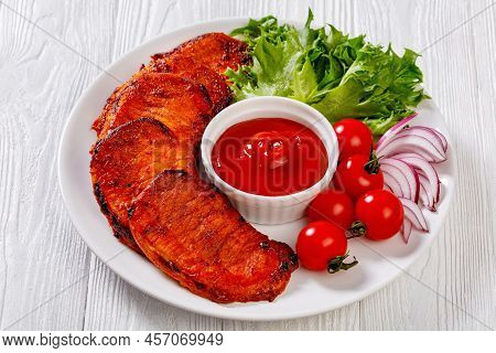 Grilled Slices Of Pork Loin Marinated In Paprika Based Sauce With Tomatoes And Lettuce, Red Onion On