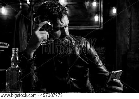 Brutal Hipster Man Drinking Alcohol. Stylish Handsome Bearded Man Enjoying Whiskey And Doing His Bus