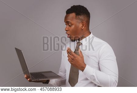 Young Black Businessman Using Laptop And Taking Notes At Worklace In Modern Office, Free Spac