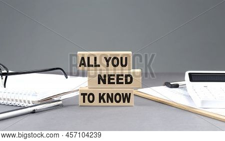 All You Need To Know Text On A Wooden Block With Notebook,chart And Calculator, Grey Background