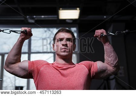 Close Up Of A Determined Bodybuilder Doing Bicep Curls In Cable Crossover Gym Machine