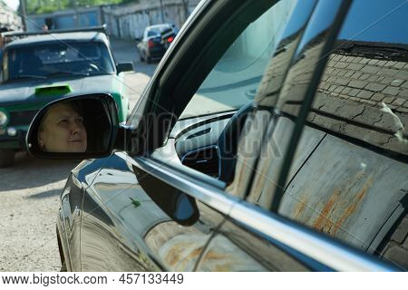 Audi Q3 In Black. Subcompact Luxury Crossover Audi Q3. View Of The Side Mirror Reflecting The Face O