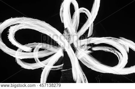 Sensual Woman Artist Perform Fiery Twirly Trails By Spinning Flaming Pois During Fire Performance In