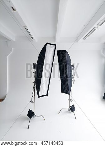 Lighting Equipment On A Cyclorama In Modern Photo Studio. Two Stripboxes On A C-stand On A Clean Whi