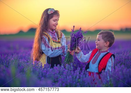 Portrait Of Children Boy And Girl In Traditional Bulgarian Folklore Costume In Lavender Field During