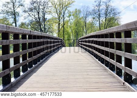 Musical Pedestrian Bridge With Natural Colour Wooden Deck And Dark Stained Wooden Railings Going To 