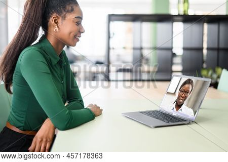 Two Female Coworkers Talking Through Video Call. Business Women Using App On Laptop For Video Chat, 